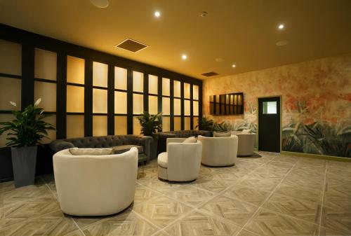 a lobby with white chairs and couches at Park hall Hotel & Spa Lancashire, a member of Radisson Individuals in Eccleston