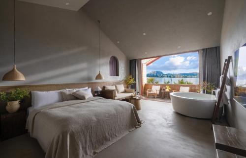 a bedroom with a large bed and a bath tub at QiPan Holiday hotel Lugu Lake in Ninglang