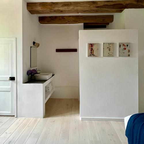 a white room with a sink and a mirror at Le manoir de Jasmine in Chabrignac
