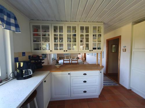 a kitchen with white cabinets and a counter top at Boende på SydKoster med havsutsikt och nära till bryggor in Strömstad