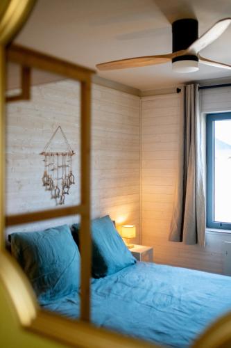 une chambre avec un lit bleu et une fenêtre dans l'établissement Histoires d'Ault - maison vue mer et jardin, à Ault
