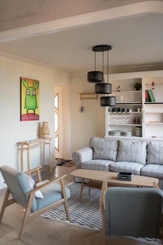 un salon avec un canapé et une table dans l'établissement Histoires d'Ault - maison vue mer et jardin, à Ault