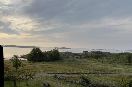 a view of a field with a body of water at Boende på SydKoster med havsutsikt och nära till bryggor in Strömstad
