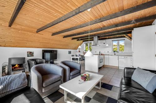 a living room with couches and a table and a kitchen at Just 500 Meters From Both The Sea And The Town, This Lovely, Well-Maintained Holiday Home Is Situated in Ringkøbing
