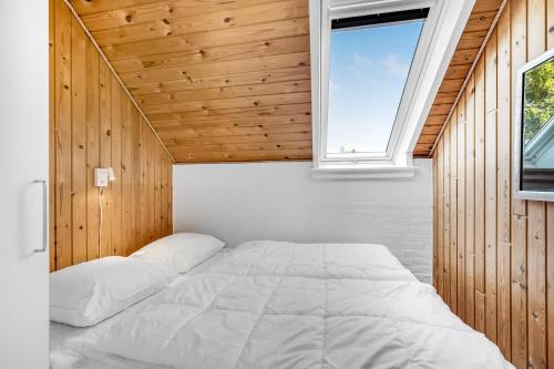 a bed in a room with a window at Just 500 Meters From Both The Sea And The Town, This Lovely, Well-Maintained Holiday Home Is Situated in Ringkøbing