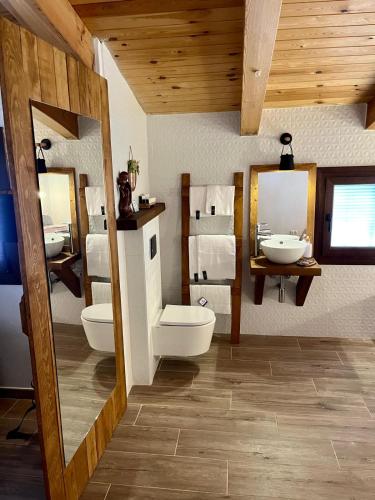 a bathroom with two sinks and two mirrors at Loft Rural El Pajar del Molino in Benamahoma