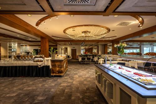 a restaurant with buffet tables and a chandelier at AllgäuStern Hotel in Sonthofen