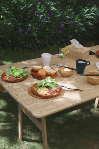 a wooden table with plates of food on it at 小白屋包棟民宿 in Eluan