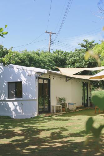 a small white house with a yard at 小白屋包棟民宿 in Eluan