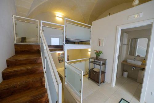 a room with a staircase and a bathroom with a sink at Bbatà in Grottaglie