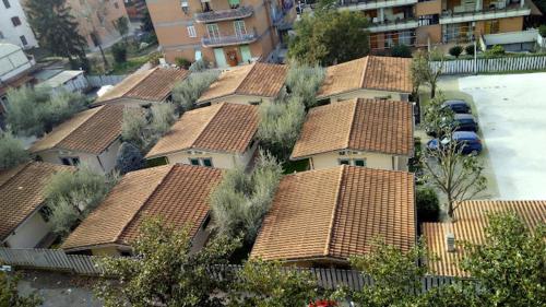 a group of houses with brown roofs and a parking lot at Hotel Tecla in Fonte Nuova