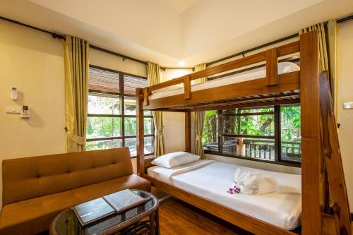 1 Schlafzimmer mit 2 Etagenbetten und einem Sofa in der Unterkunft Princess Kamala Beachfront Hotel - SHA Extra Plus in Kamala Beach