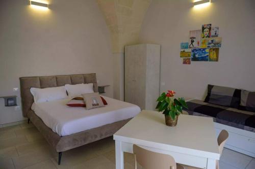 a bedroom with a bed and a table and a couch at Bbatà in Grottaglie