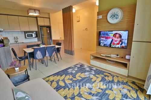 a living room with a tv and a dining room at Nature Home - Swiss Garden Resort Residences in Kuantan
