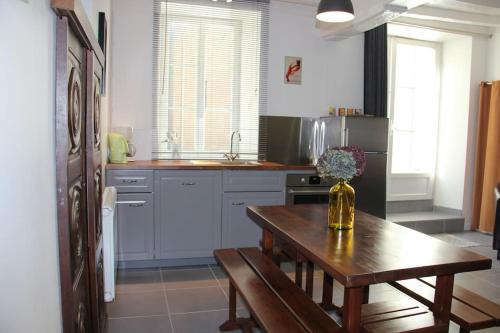 une cuisine avec une table en bois et un vase de fleurs. dans l'établissement Maison au coeur de Cancale à 300m de la plage, à Cancale
