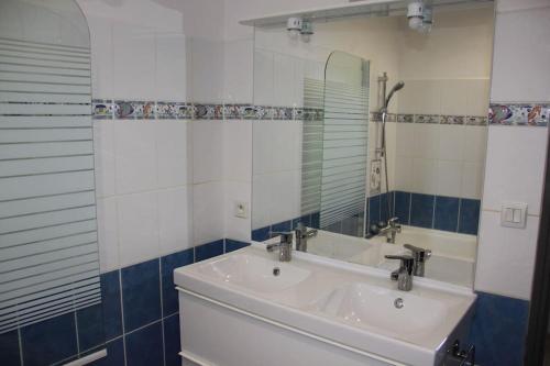 une salle de bain avec un lavabo et un miroir dans l'établissement Maison au coeur de Cancale à 300m de la plage, à Cancale