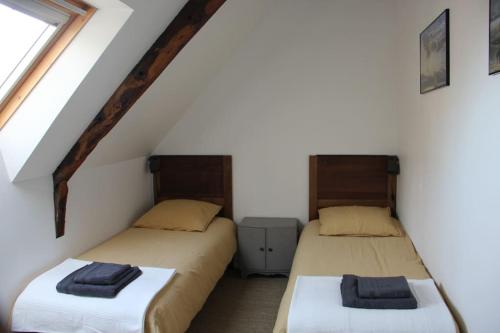 deux lits jumeaux dans une chambre avec fenêtre dans l'établissement Maison au coeur de Cancale à 300m de la plage, à Cancale