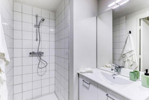une salle de bain blanche avec une douche et un lavabo dans l'établissement Student Factory Clermont République, à Clermont-Ferrand