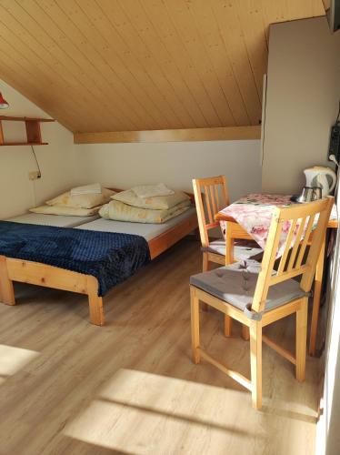 a room with two beds and two chairs in it at DG EWA w Polańczyku in Polańczyk