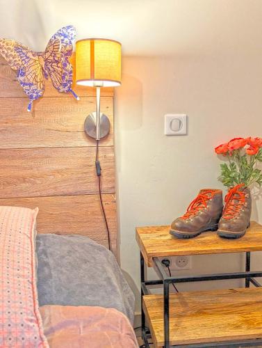 a bedroom with a bed and a table with shoes on it at Le Panorama des Alpilles in Aureille