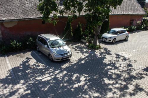 two cars parked in a parking lot next to a building at Air&Day in Vecsés