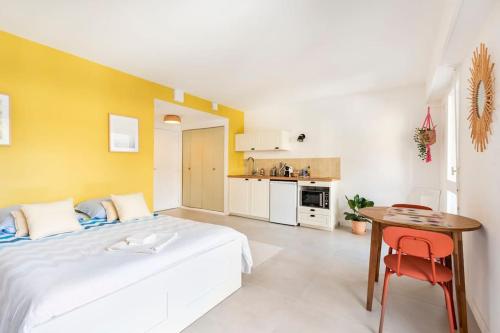 une chambre avec un lit et une table et une cuisine dans l'établissement Studio hyper-centre avec parking, à Libourne