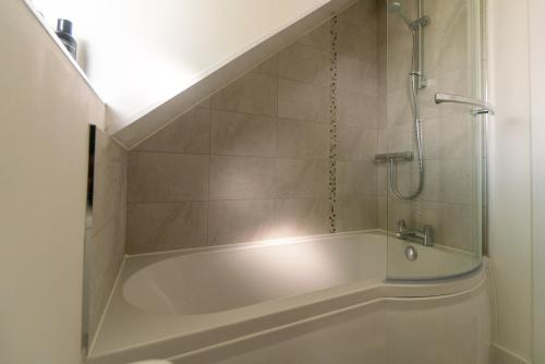 a bathroom with a bath tub with a shower at Beautiful town centre apartment in Huntingdon