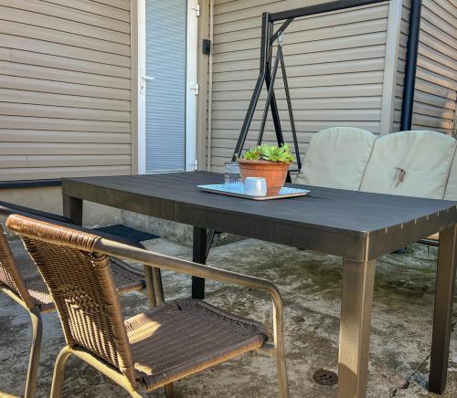 a picnic table with two chairs and a plant on it at Oakwood park apartment in Kaunas