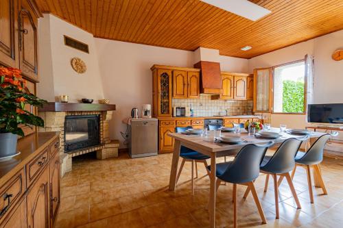 une cuisine avec une table et des chaises ainsi qu'une cheminée dans l'établissement L'Écrin Gascon - Maison climatisée à Fleurance, à Fleurance