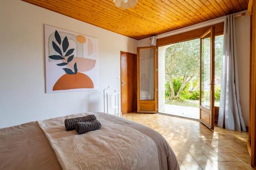 - une chambre avec un lit et une grande porte coulissante en verre dans l'établissement L'Écrin Gascon - Maison climatisée à Fleurance, à Fleurance