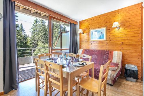 une salle à manger avec une table et des chaises et un balcon dans l'établissement Aventures à Chamrousse - Appt 34 m² avec terrasse, à Chamrousse
