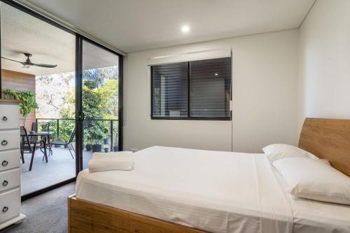 a bedroom with a large bed and a balcony at Stones Corner Vista Stay in Brisbane