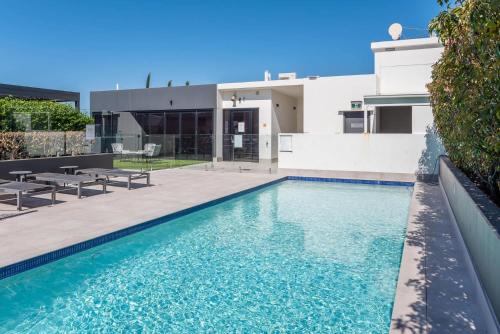 a swimming pool in front of a house at Stones Corner Vista Stay in Brisbane