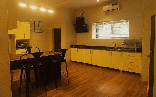 a kitchen with a counter and chairs in a room at 17th Apartment in Enugu