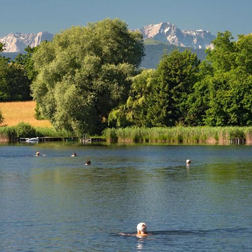 a group of people swimming in a lake at Alpenpanorama in Weilheim in Oberbayern