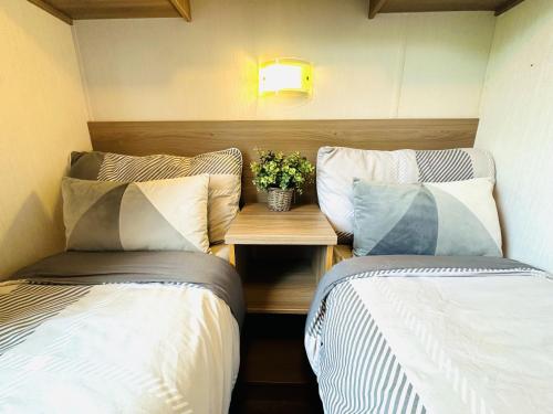 two beds in a small room with a table between them at Barn Owl Lodge in Bridlington