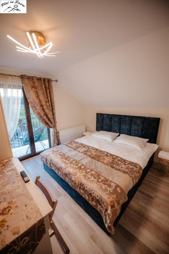 a bedroom with a large bed and a window at Casa Plai cu Soare in Vatra Dornei