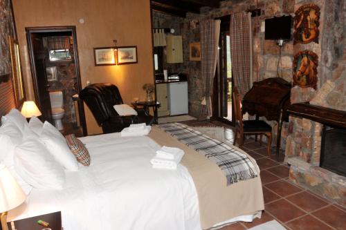 a bedroom with a white bed and a fireplace at Guest Stone Houses in Aidona in Aïdón