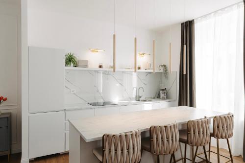 a kitchen with white cabinets and a table and chairs at La Suite del Centro in Varese