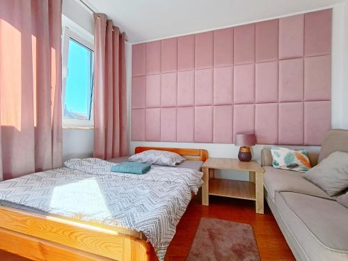 a small bedroom with a bed and a couch at pokoje przytulnie jak w domu in Kraków