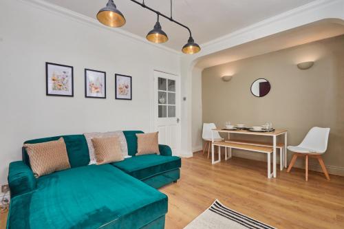 a living room with a green couch and a table at Lovely 4-Bedroom House in Hartlepool - Street Parking in Hartlepool