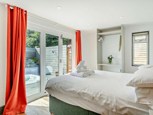 a bedroom with a large bed with red curtains at 2 Bed in Westward Ho 41865 in Westward Ho