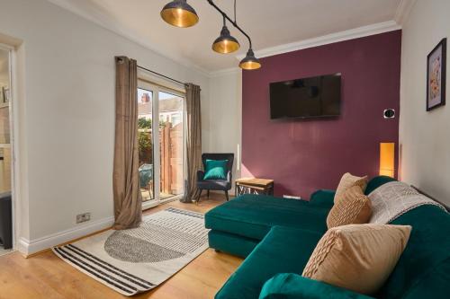 a living room with a green couch and a tv at Lovely 4-Bedroom House in Hartlepool - Street Parking in Hartlepool