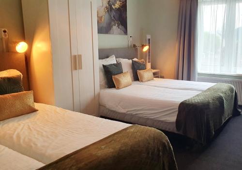 a hotel room with two beds and a window at Herberg de la Ruïne in Valkenburg