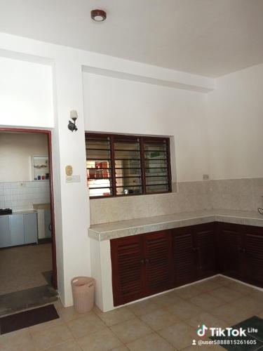 a kitchen with brown cabinets and a window at Kamsons villa accommodation in Mombasa