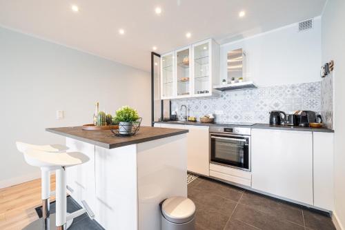 une cuisine avec des armoires blanches et un comptoir dans l'établissement Panoramic Sea View - 1 Bdr Promenade des Anglais, à Nice