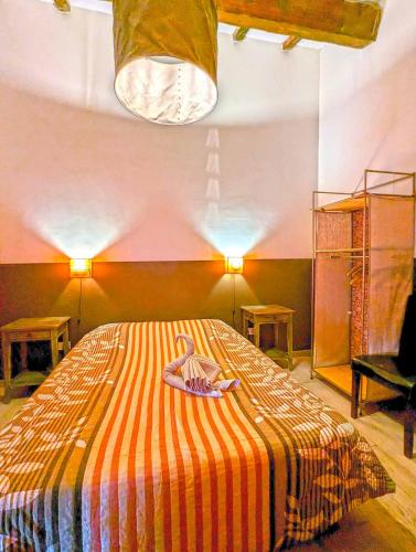 a bedroom with a bed with a striped blanket at Le Panorama des Alpilles in Aureille