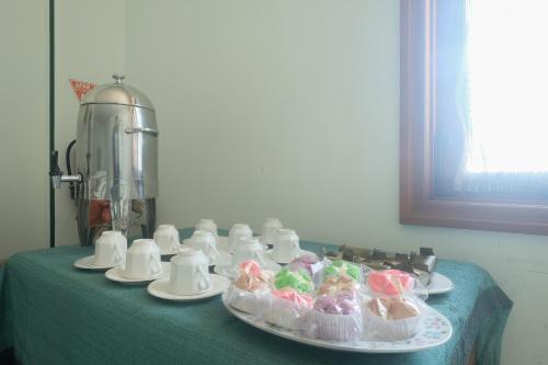 a table with plates of cupcakes on a table with a mixer at RedDoorz near XT Square Yogyakarta in Yogyakarta
