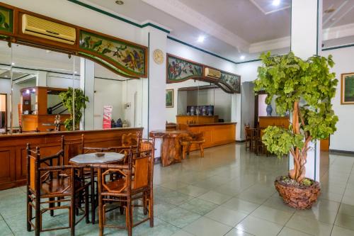 a restaurant with a table and chairs and a tree at RedDoorz near XT Square Yogyakarta in Yogyakarta