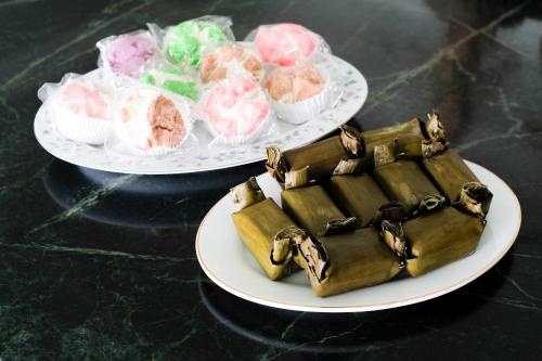 two plates of cakes and cupcakes on a table at RedDoorz near XT Square Yogyakarta in Yogyakarta